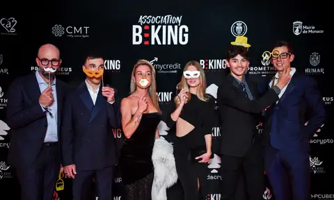 Sei ospiti in abiti eleganti posano con baffi finti, maschere e occhiali da photo booth davanti al fondale BEKING