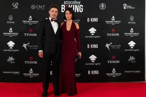 Due ospiti in abito da sera posano sul tappeto rosso davanti al fondale BEKING con gli sponsor